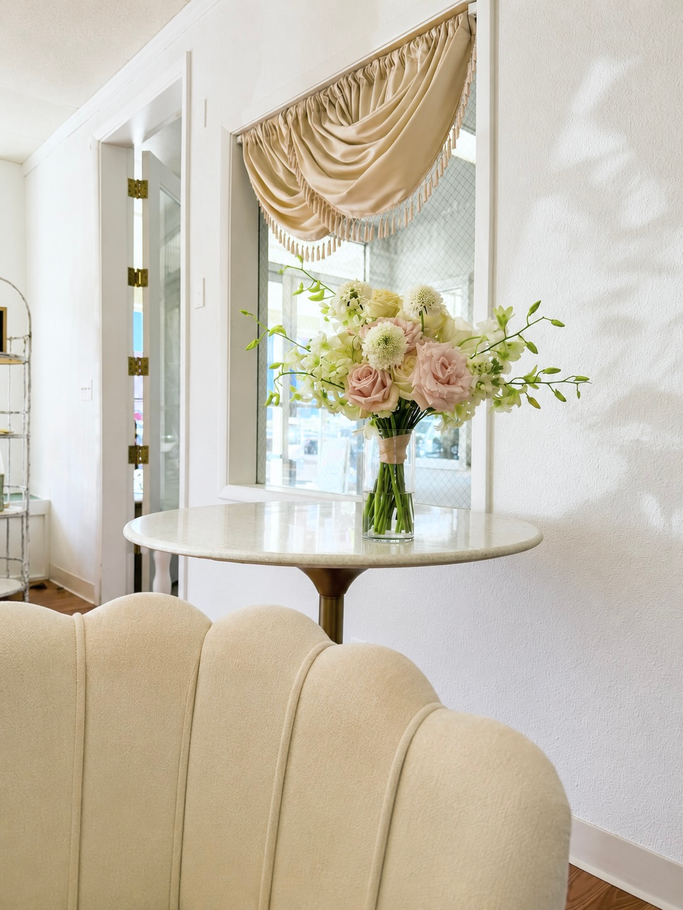 Cream-colored bench in front of a textured gold wall with a
