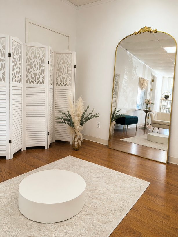 Bright minimalist living room with white furniture, wood floors, floor mirror, and folding screen divider