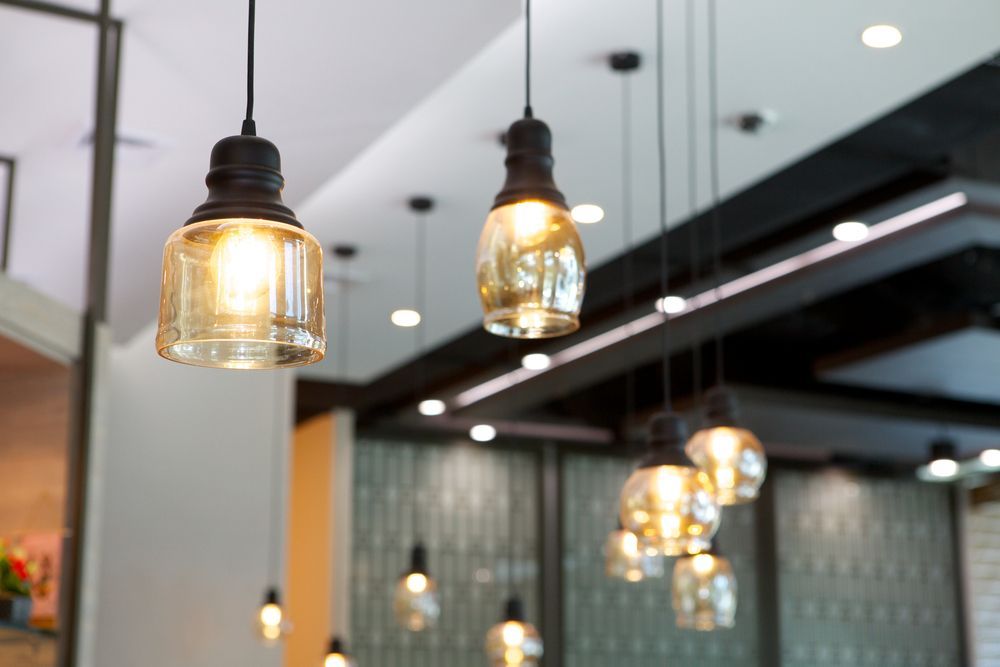 Pendant Lights With Amber-colored Bulbs Hanging From a White Ceiling — Memories Cafe @ Yorkeys Knob in Yorkeys Knob, QLD