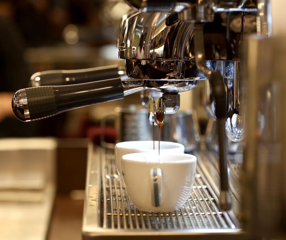 Espresso Machine Dispensing Coffee Into Two White Cups — Memories Cafe @ Yorkeys Knob in Yorkeys Knob, QLD