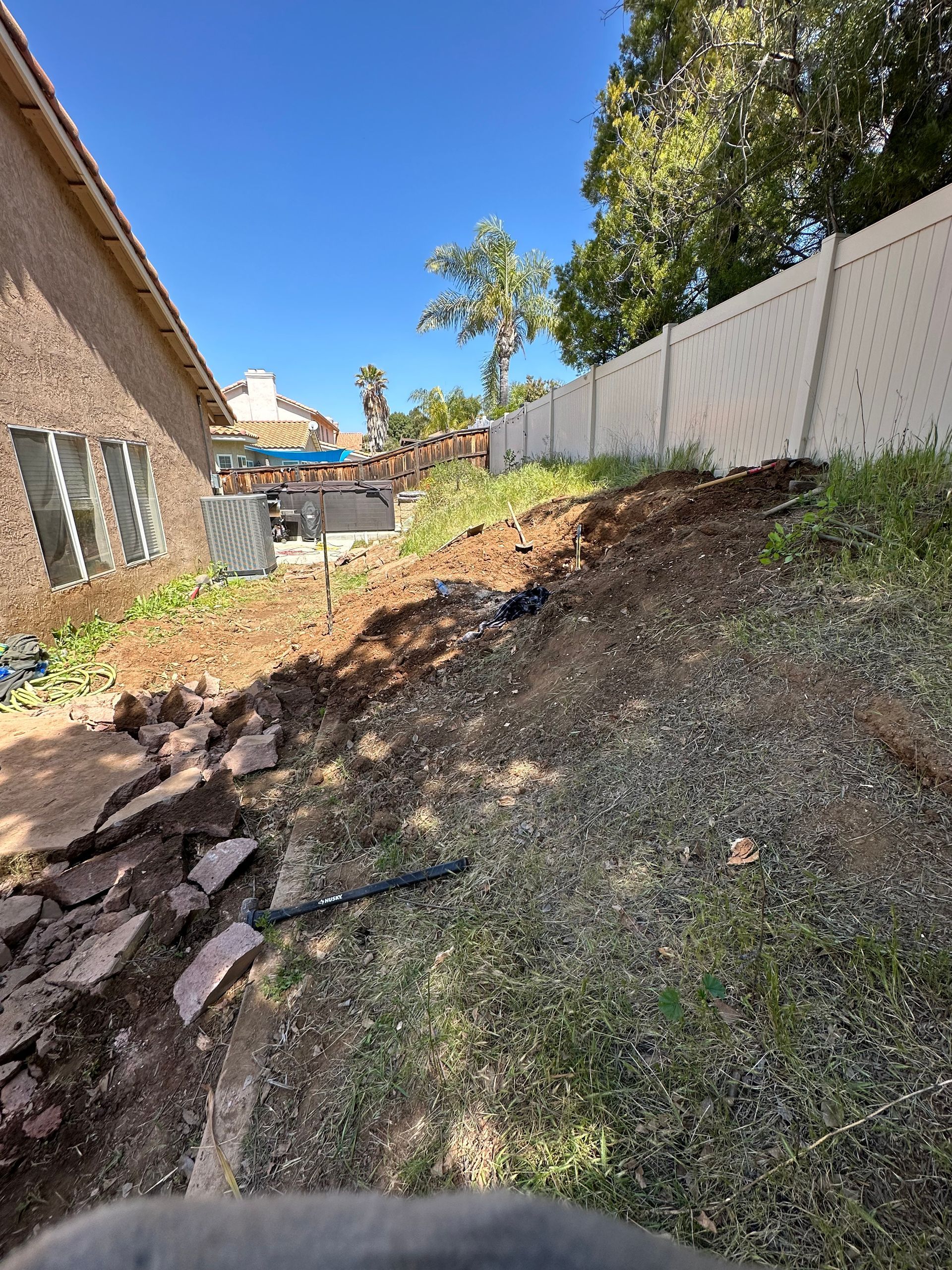 There is a lot of dirt in the backyard of a house.