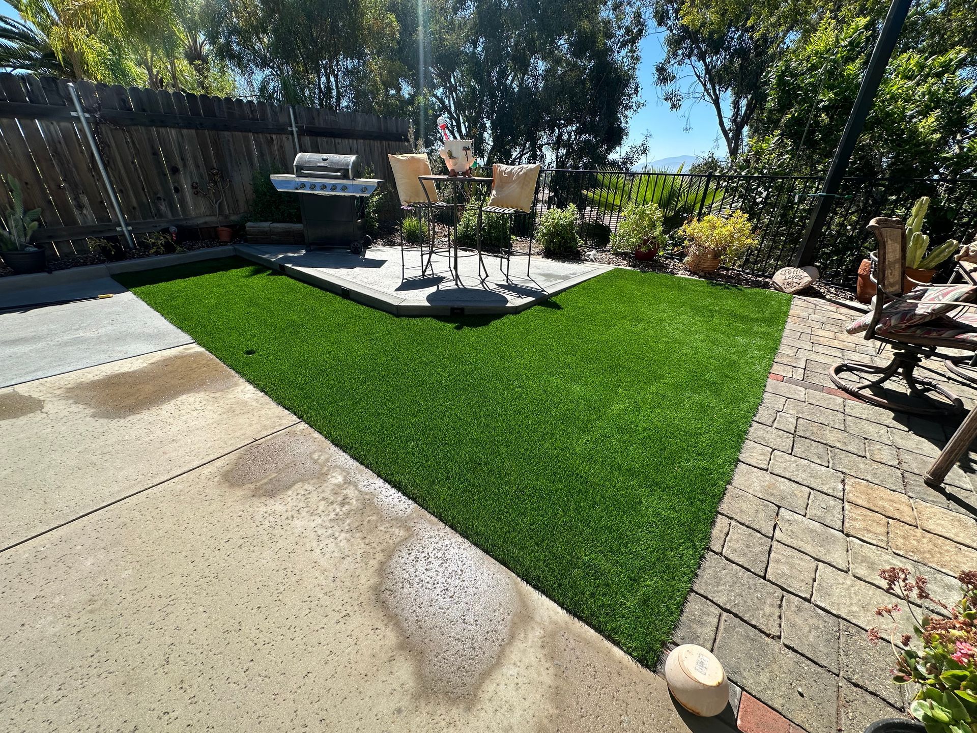 A patio with a table and chairs in the middle of it.