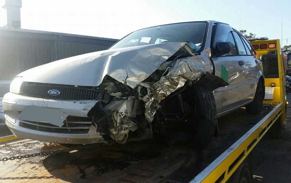A Damaged Ford Car is on a Tow Truck — Wyong and Tuggerah Towing Service in Wyong, NSW