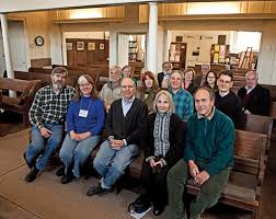 A group of people are sitting on benches in a church.