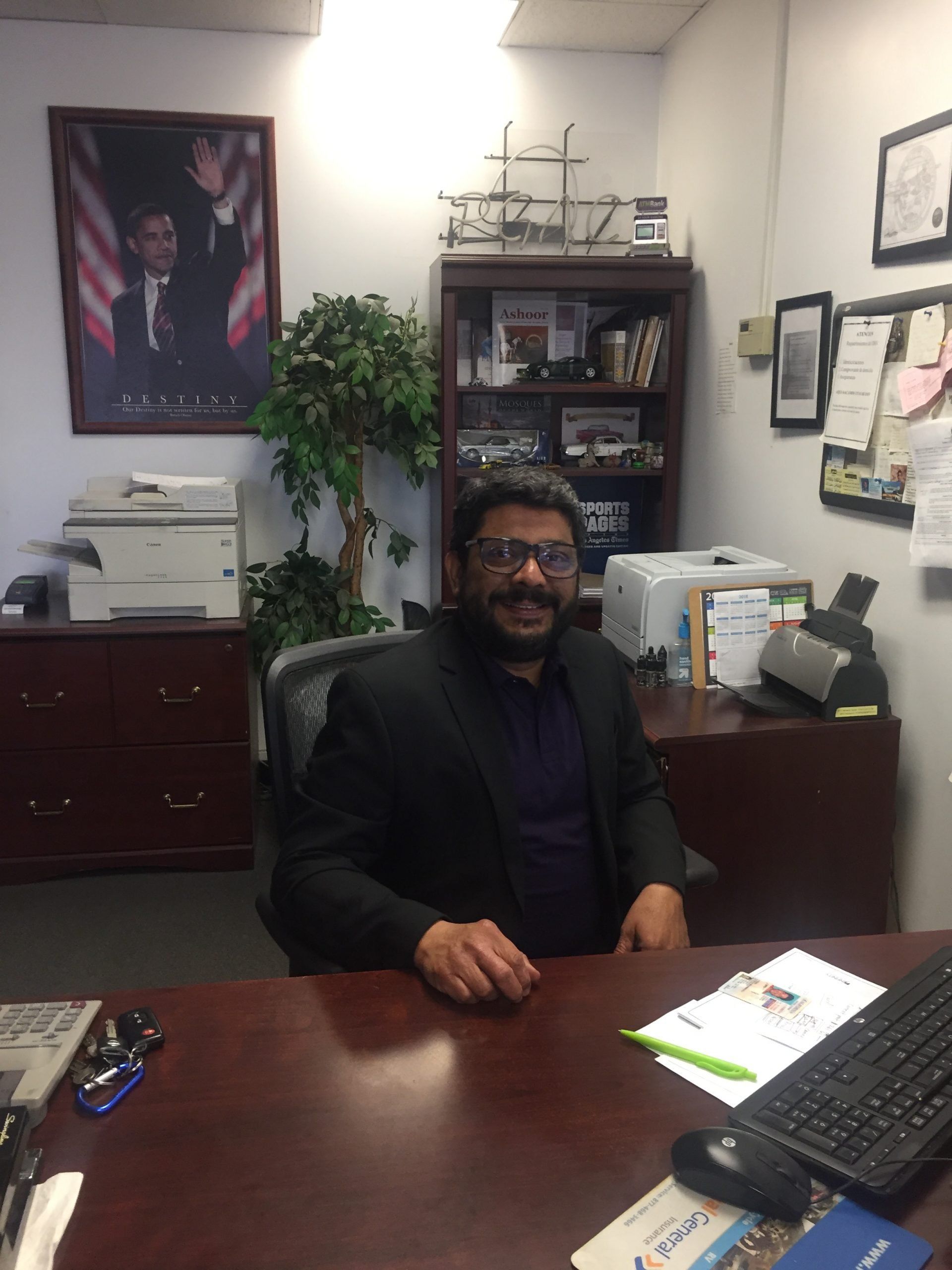 A man in a suit is sitting at a desk in an office
