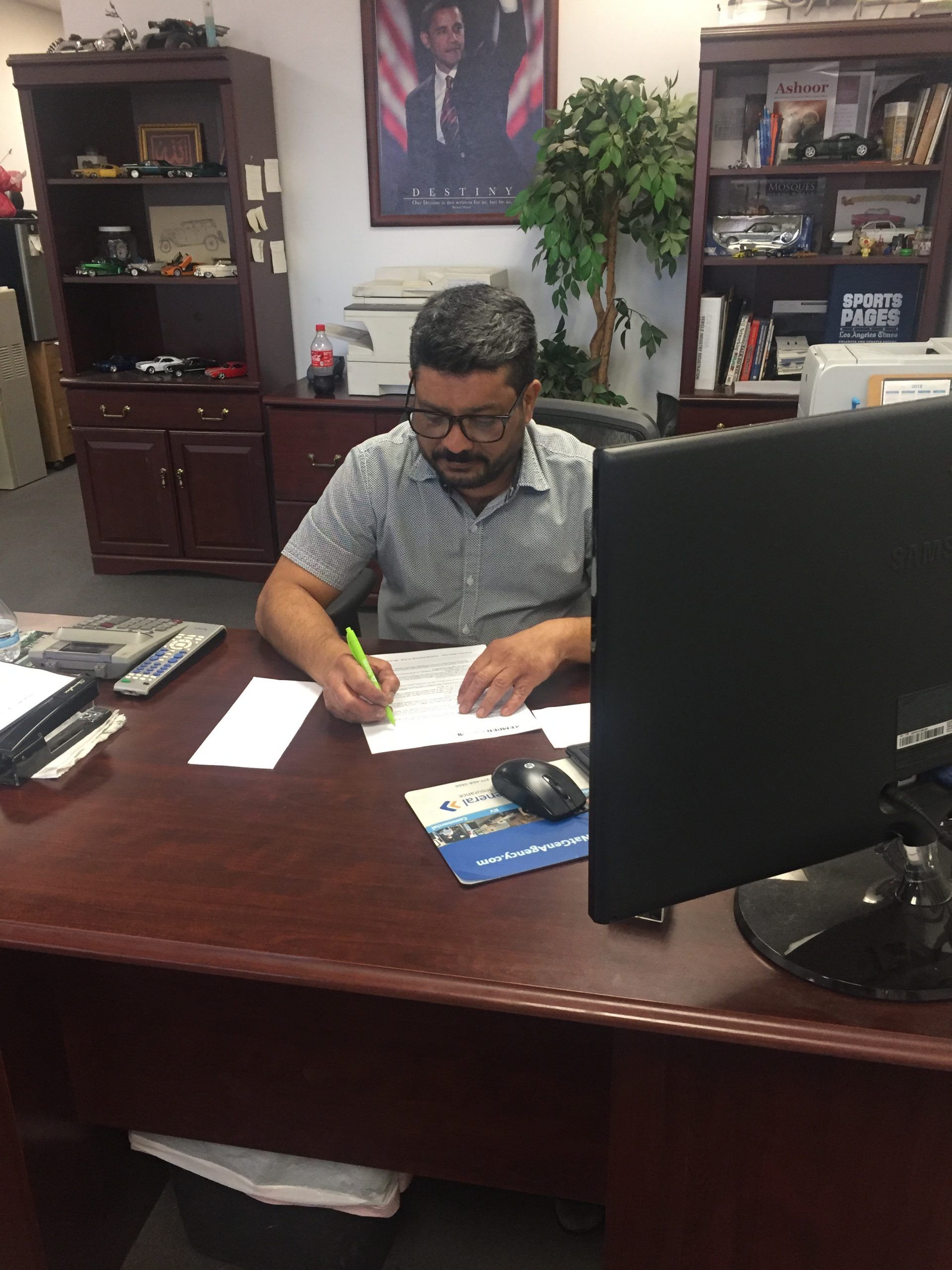 A man is sitting at a desk in front of a computer.