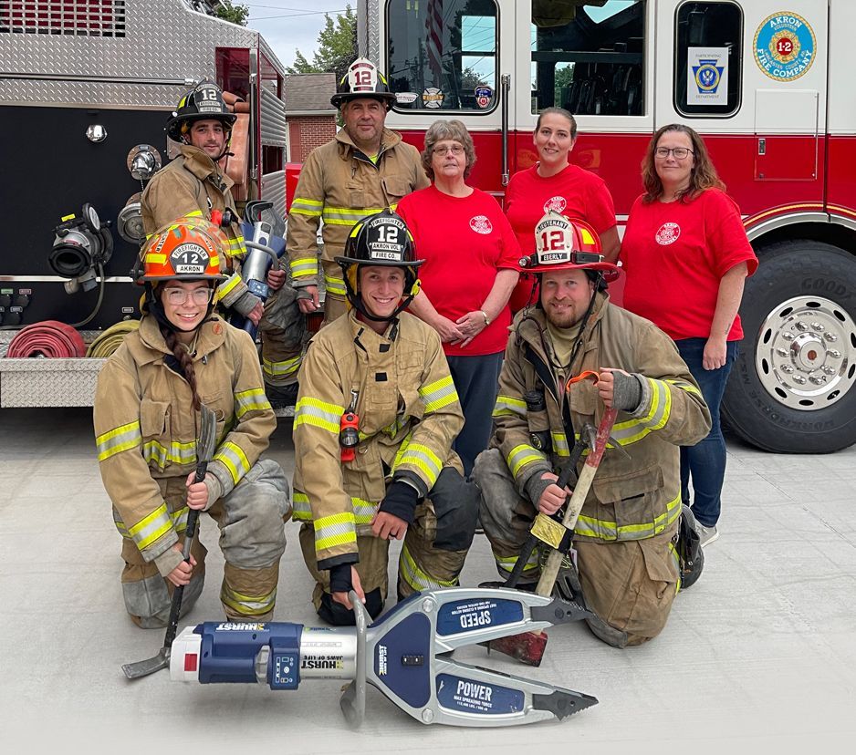 Akron Fire Company team posed in front of a fire truck