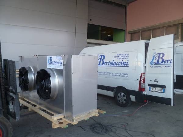 Grande unità metallica su pallet, accanto a un furgone con il logo 