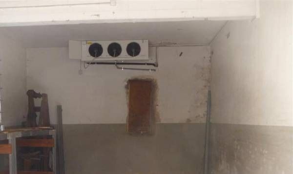 Unità di raffreddamento montata su una parete bianca e grigia all'interno di una stanza.