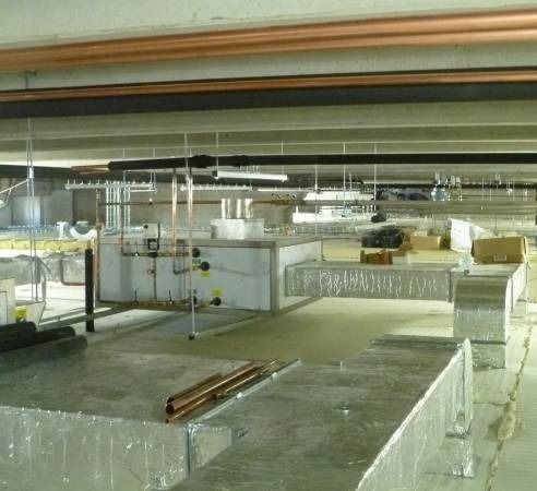 Vista interna di un edificio incompiuto; sono visibili i condotti e le tubazioni dell'impianto HVAC.