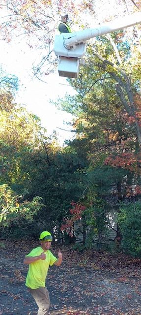 A man in a yellow shirt is running towards a bucket truck.