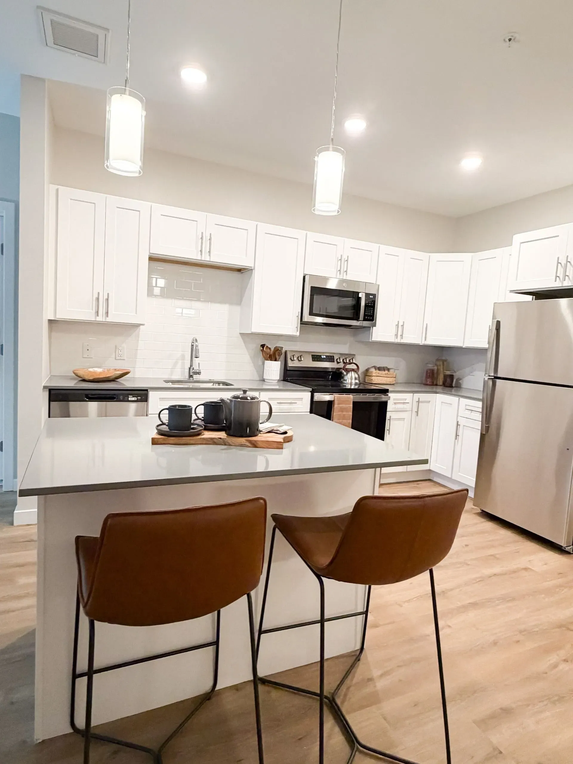 Modern kitchen with white cabinets, stainless appliances, and an island.