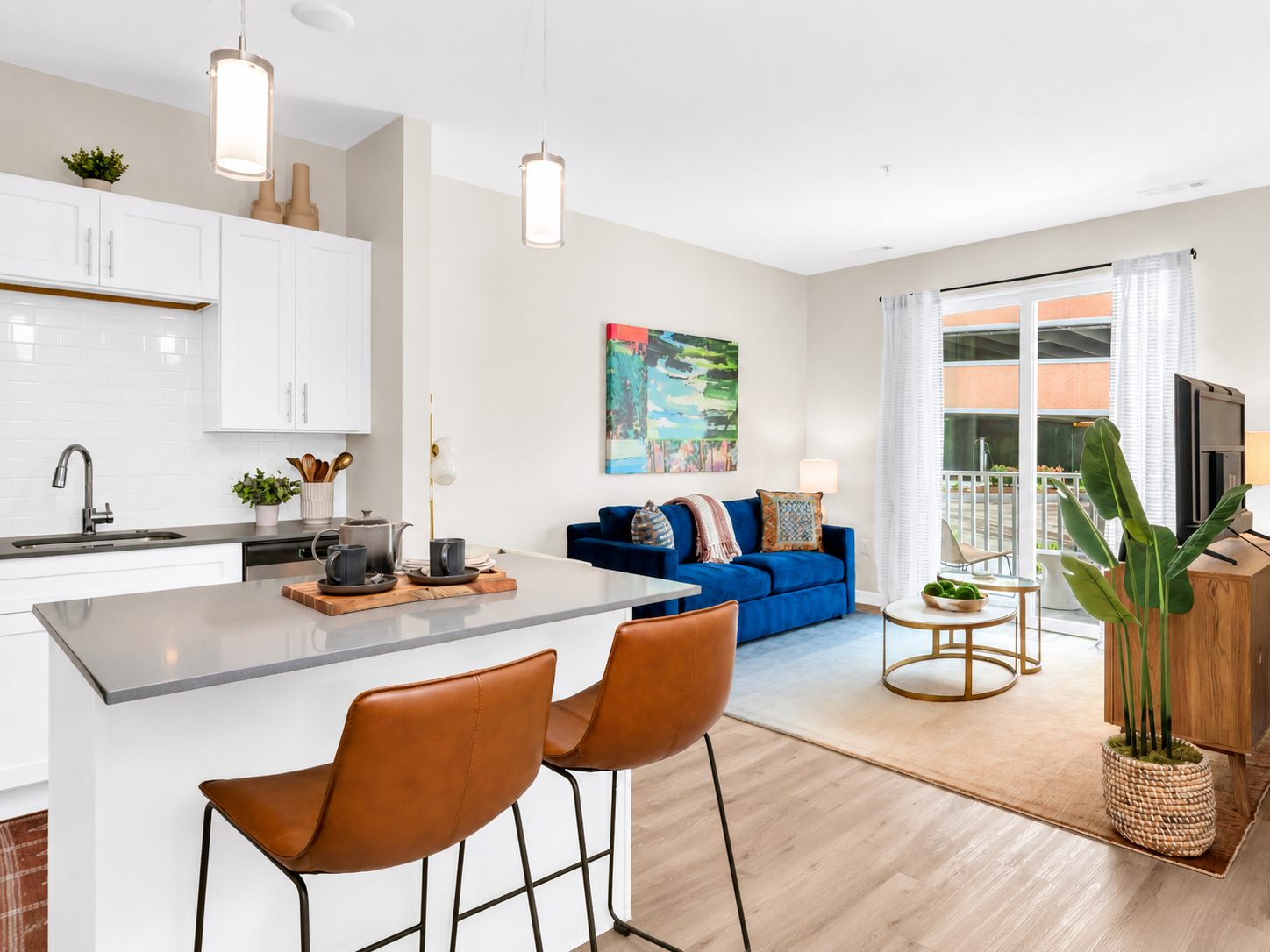 Modern white kitchen in an apartment with stainless steel appliances and an island.