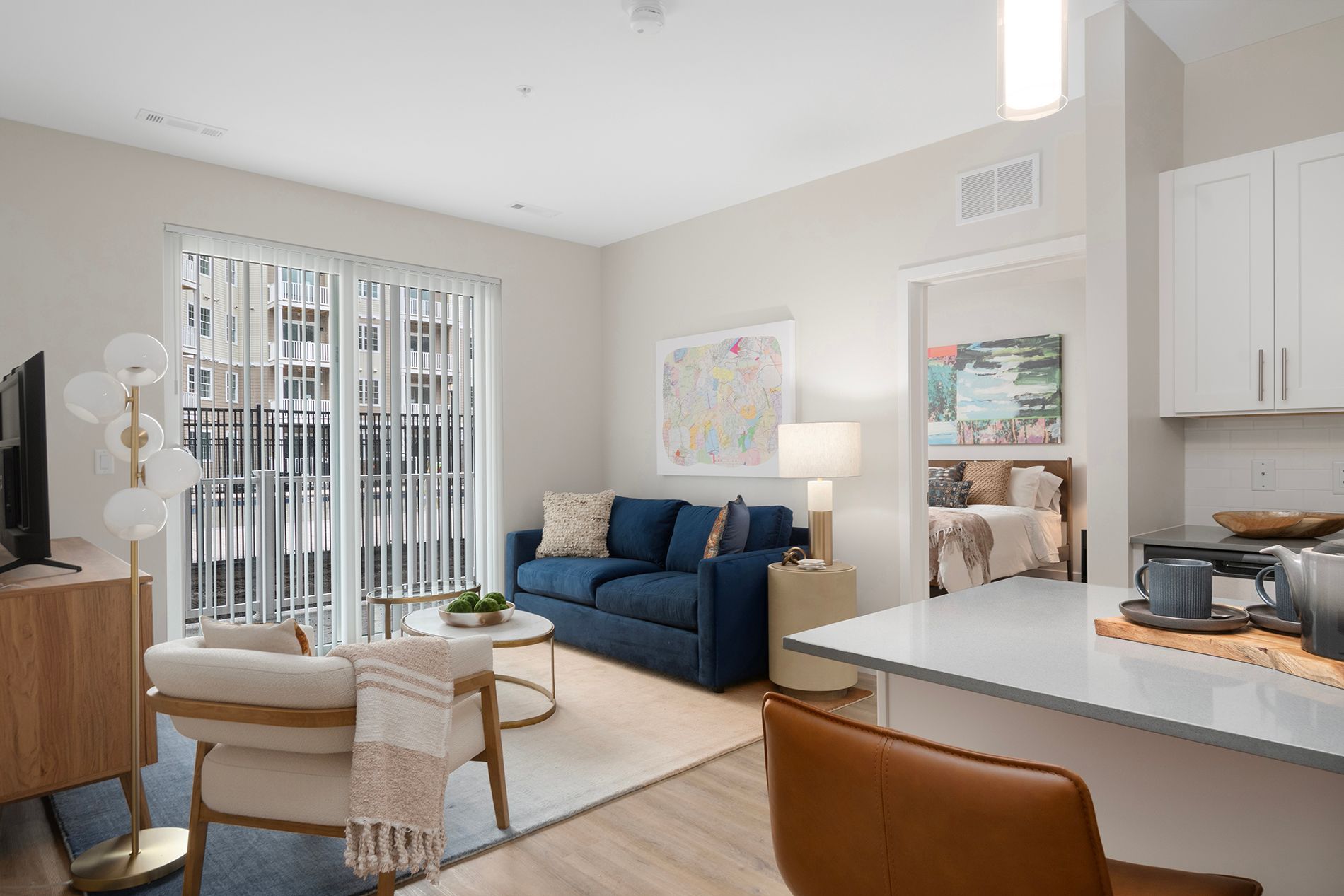 Open-concept floor plan with living room overseeing the apartment kitchen with island.