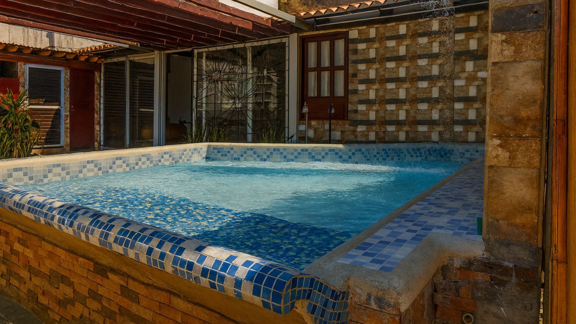Una pequeña piscina cuadrada con azulejos azules, 