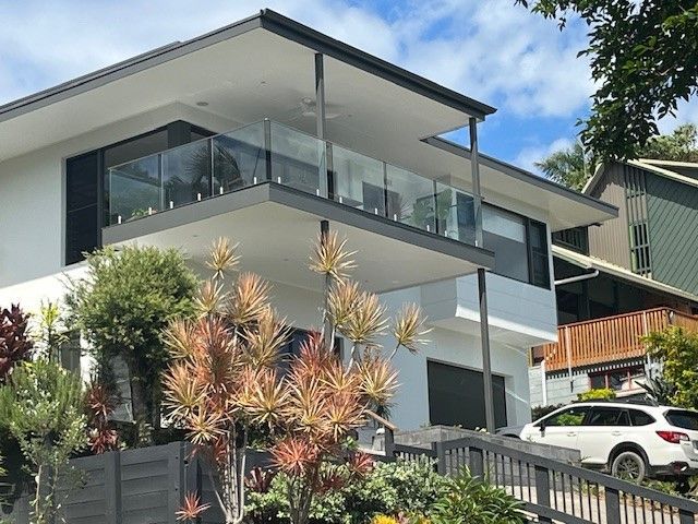 A Large White House With A Car Parked In Front Of It — Patterson Glass Works in Kempsey, NSW