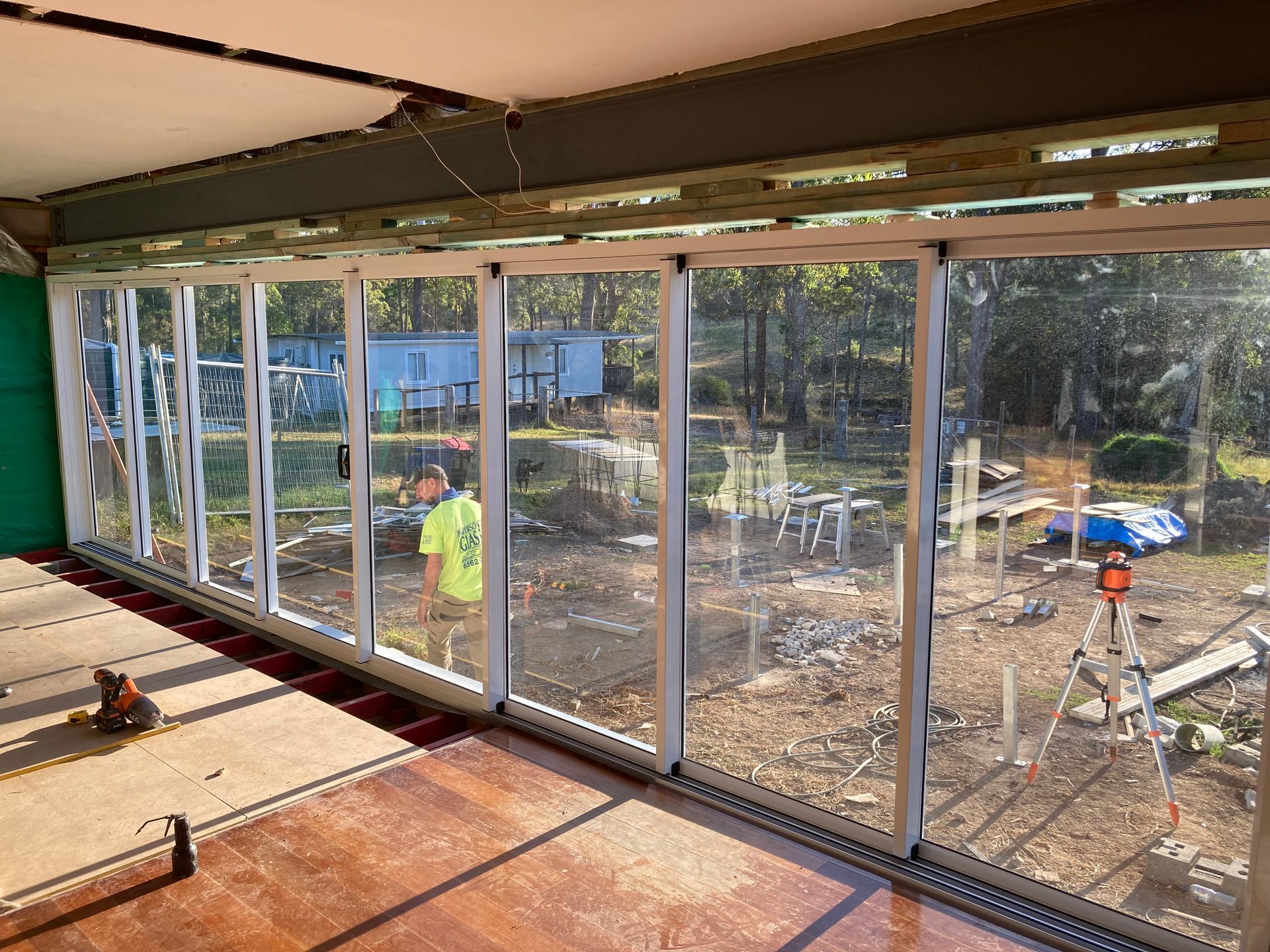 A Man Is Standing In A Room With A Lot Of Windows — Patterson Glass Works in Kempsey, NSW