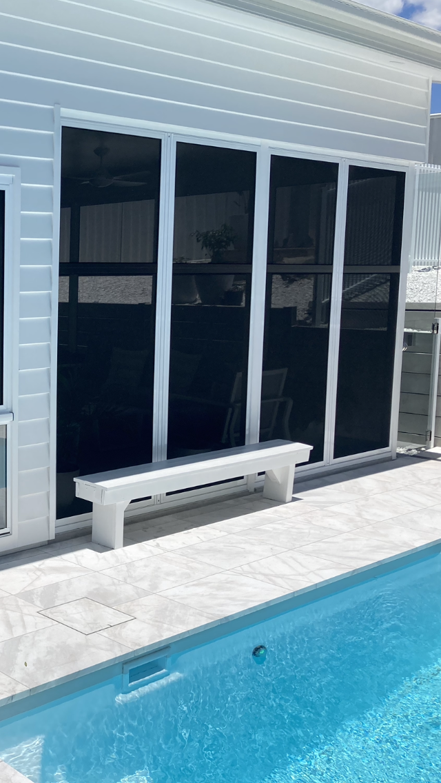 A White Bench Is Sitting Next To A Swimming Pool — Patterson Glass Works in Crescent Head, NSW