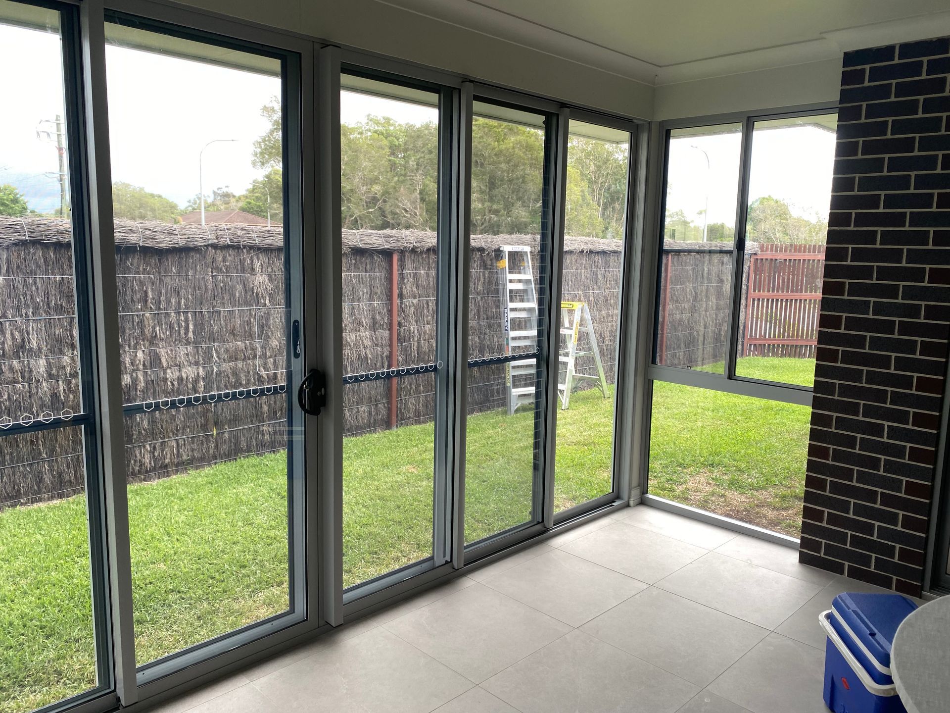 A Living Room With Sliding Glass Doors Leading to a Garden — Patterson Glass Works in Kempsey, NSW
