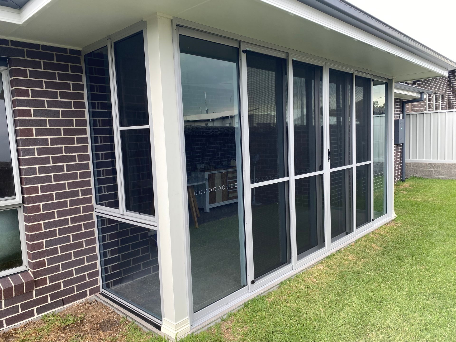 A House With A Screened In Porch And Sliding Glass Doors — Patterson Glass Works in Kempsey, NSW