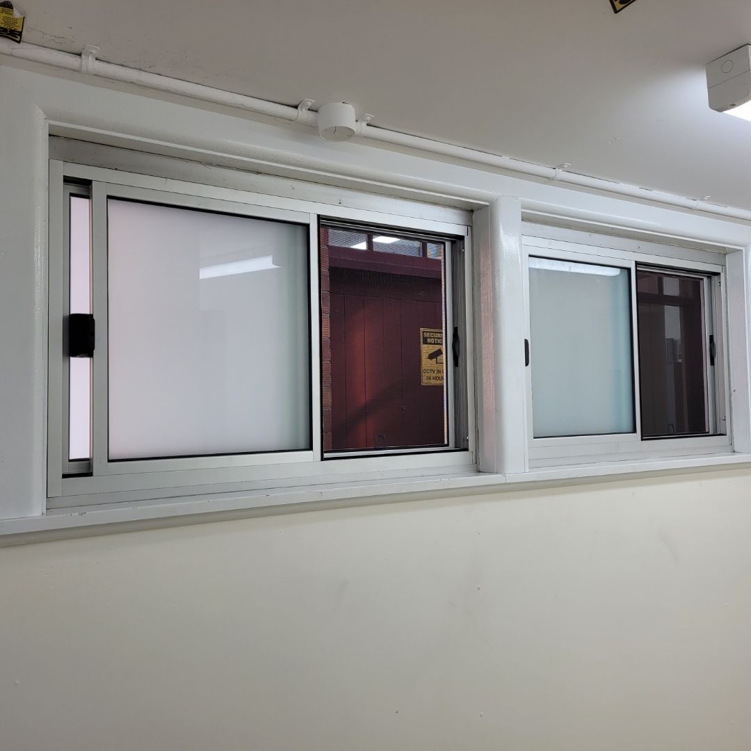 A Brick Building With a Sliding Glass Door and a Sign That Says ' Surger ' on It — Patterson Glass Works in Kempsey, NSW