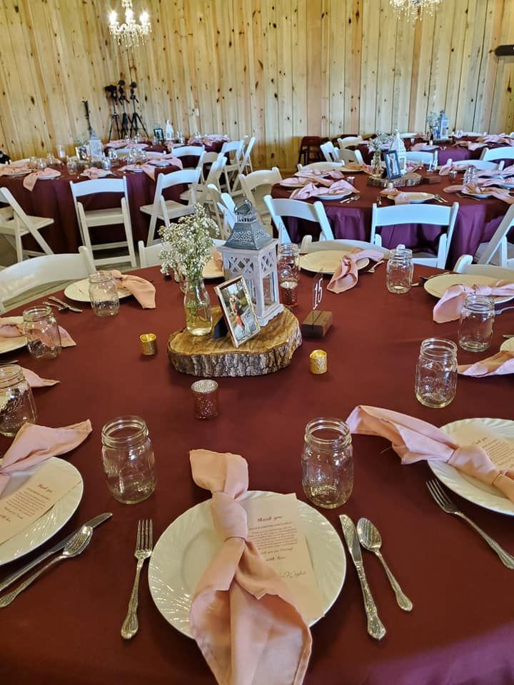 A table set for a wedding reception with plates , utensils , and candles.