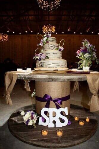 A wedding cake is sitting on top of a wooden table.