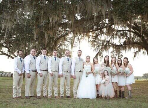 The bride and groom are posing for a picture with their wedding party.