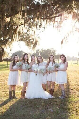 A bride and her bridesmaids are posing for a picture under a tree.