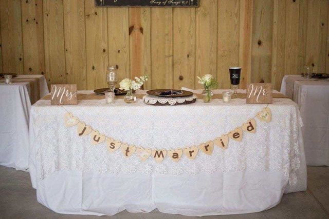 A table with a cake on it and a banner that says `` just married ''.