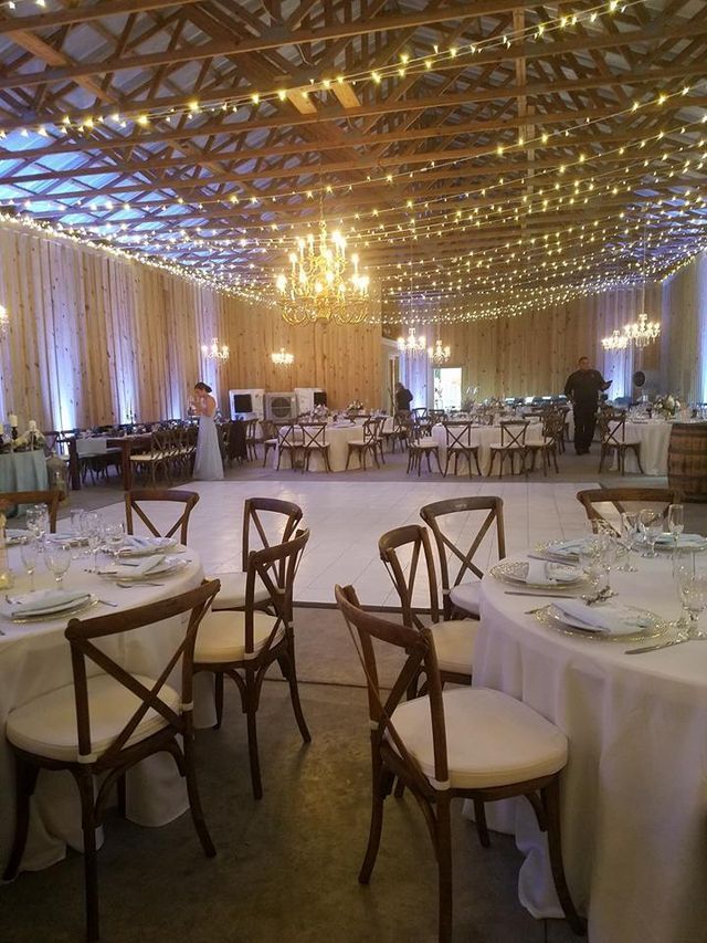 A large room with tables and chairs set up for a wedding reception.