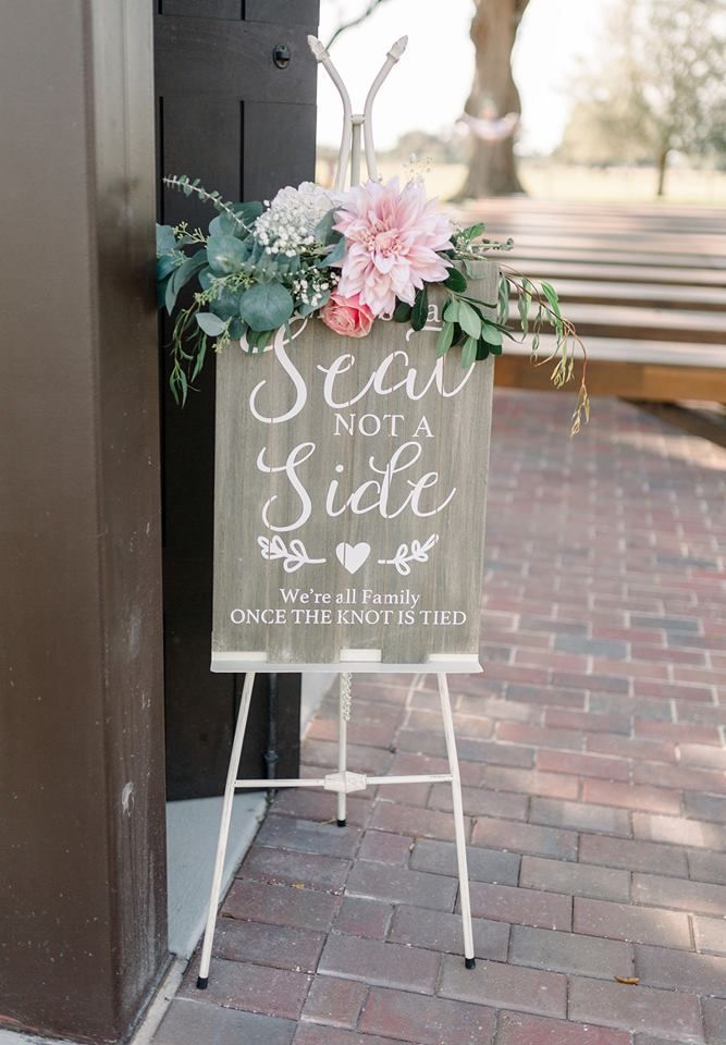 A wooden sign that says `` seat not a side '' is sitting on a white easel.