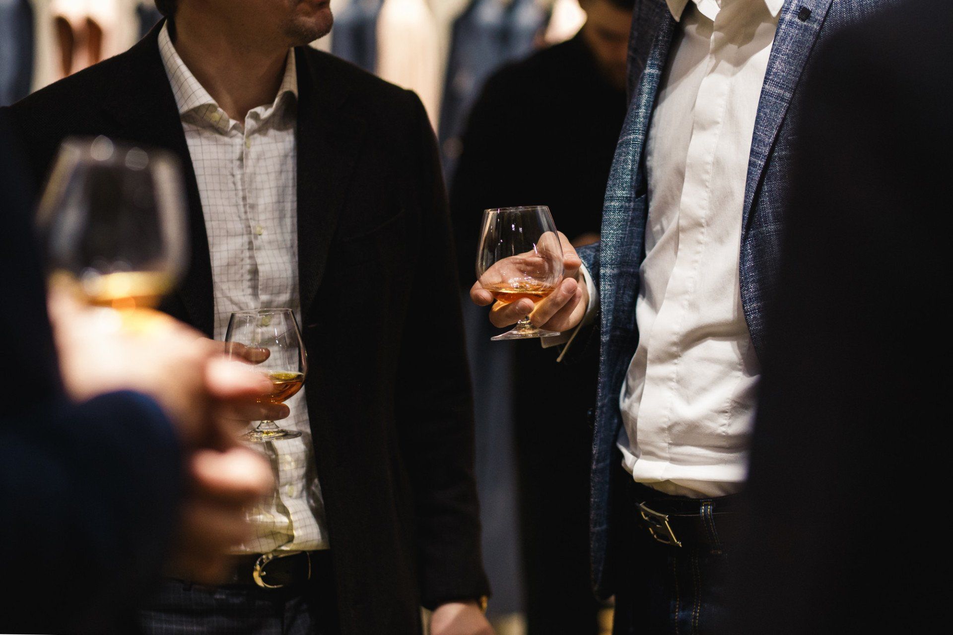 A group of men are standing next to each other holding wine glasses.