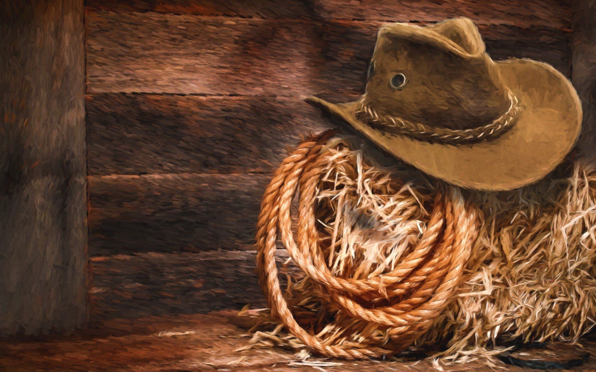 A cowboy hat is sitting on top of a pile of hay.