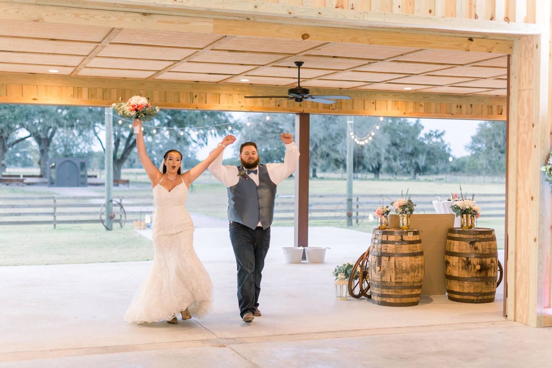 A bride and groom are walking down the aisle at their wedding reception.