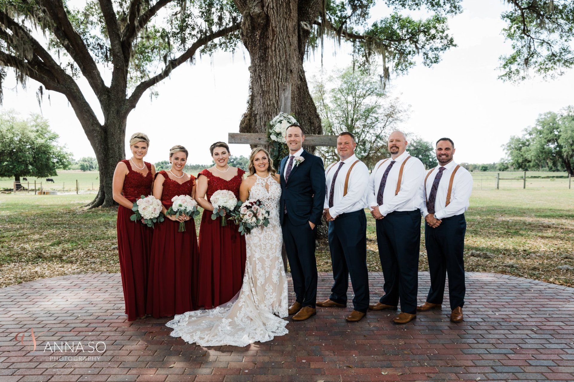 The bride and groom are posing for a picture with their wedding party.