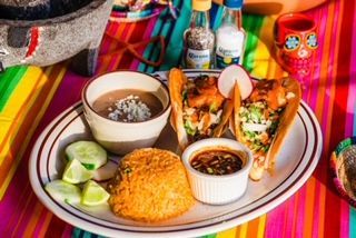 A plate of food is sitting on a colorful table cloth.