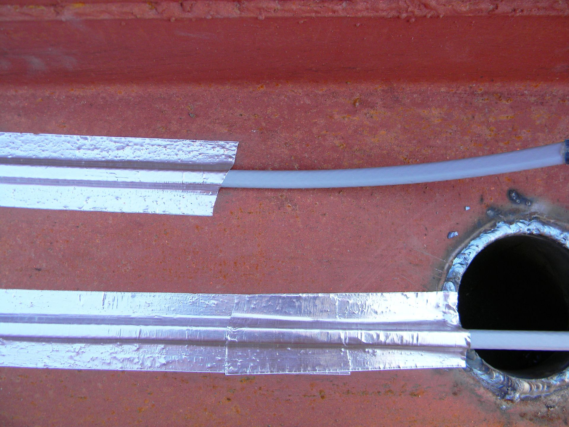 Close-up view of a snow-filled gutter on a roof, strung with colorful Christmas lights.