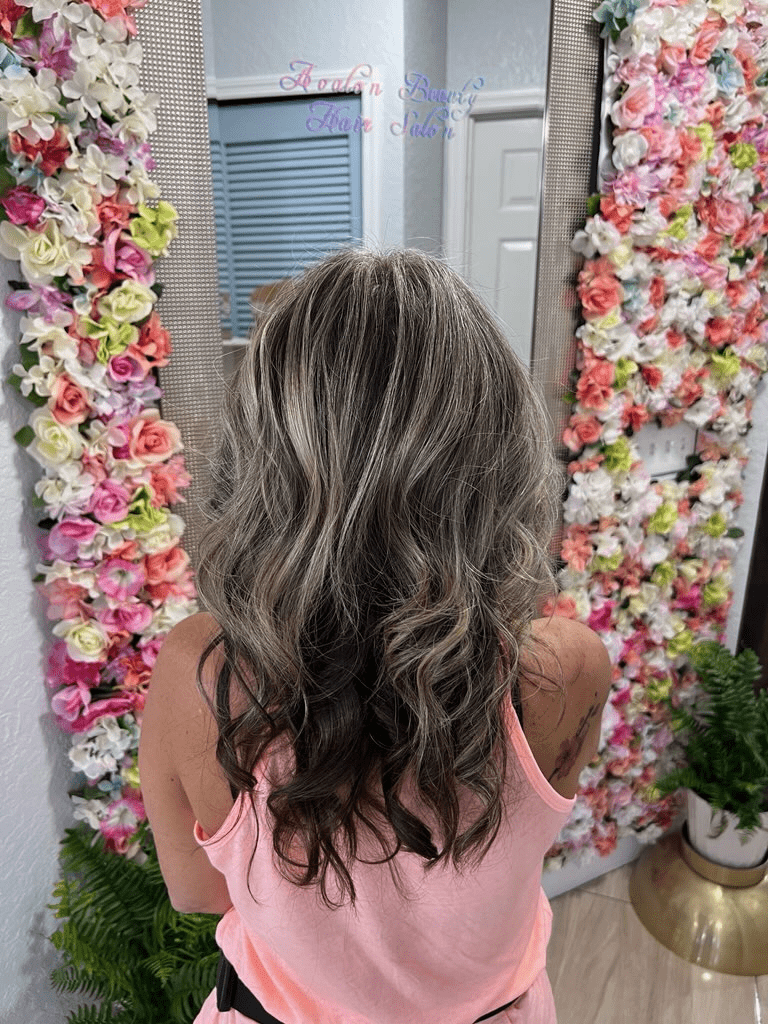 A woman is standing in front of a mirror with flowers on it.