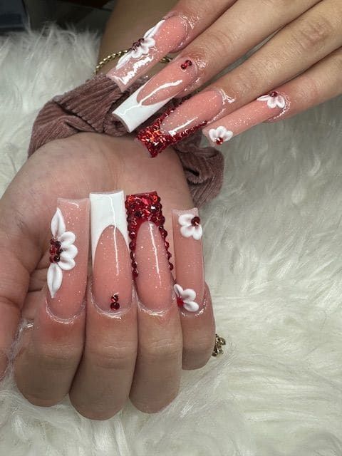 A woman 's hand with long nails and a flower design on them.