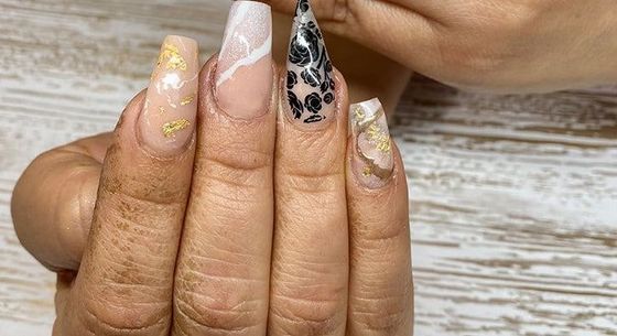 A close up of a person 's nails on a wooden table.