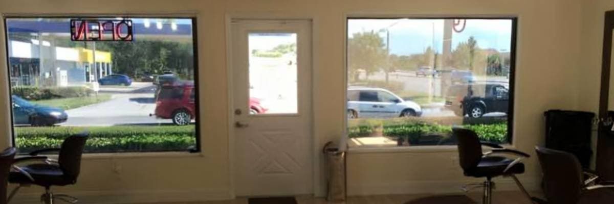 A hair salon with two chairs and two windows.