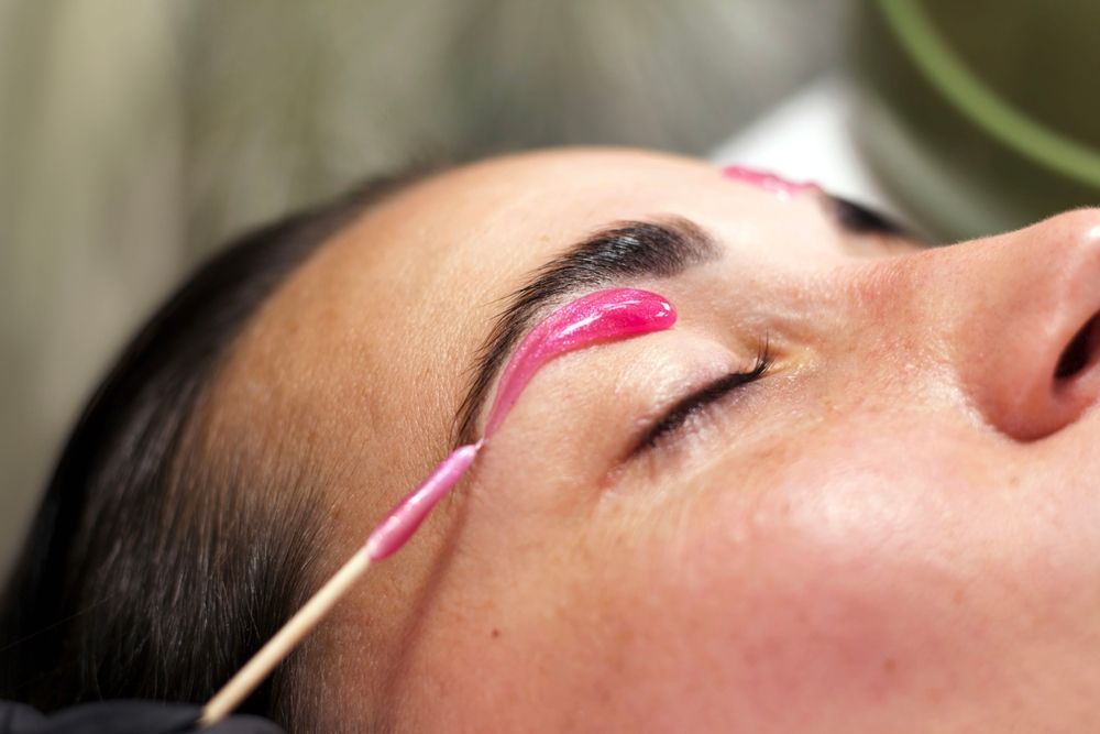 A woman is getting her eyebrows waxed at a beauty salon.