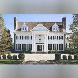 A large white house with black shutters and a driveway