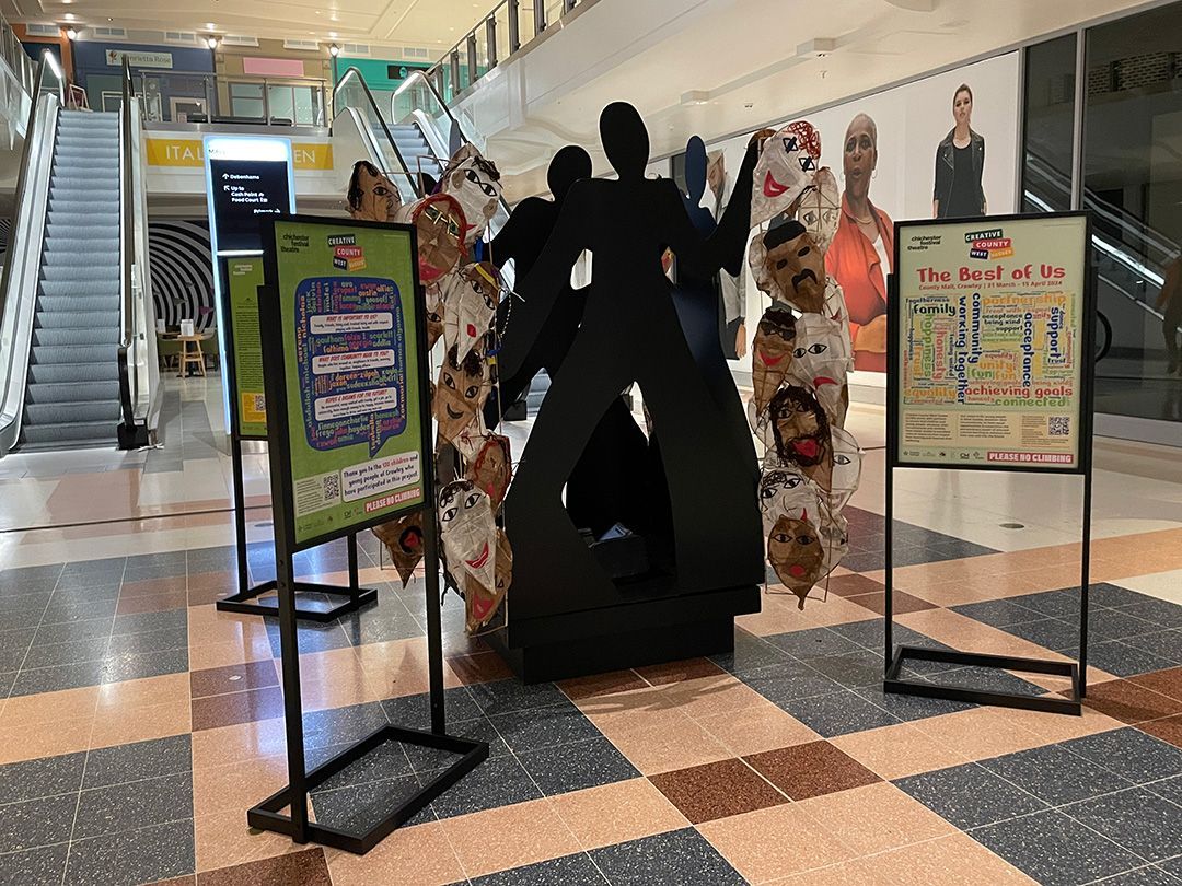A statue of two people standing next to each other in a shopping mall.