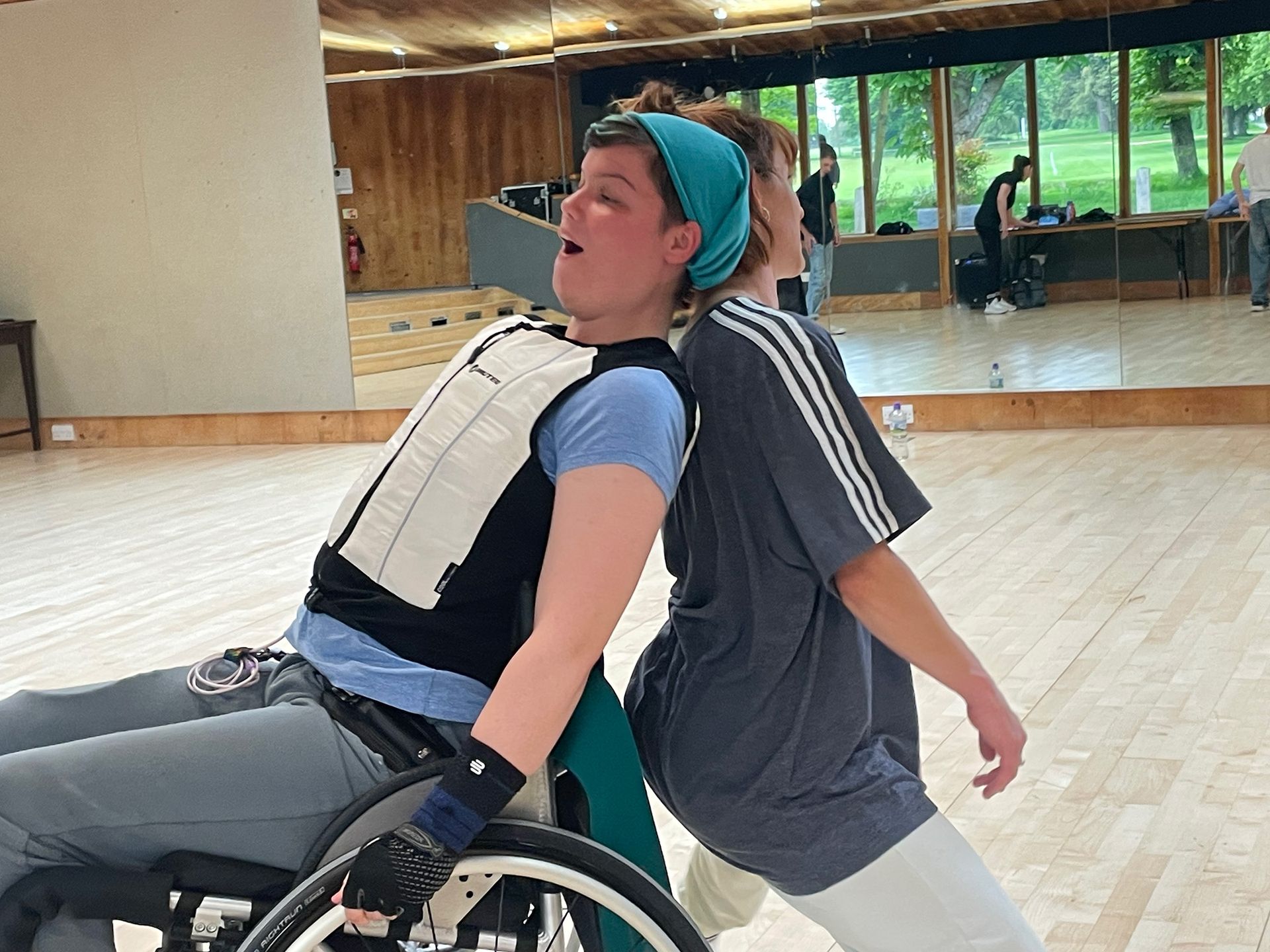 A woman in a wheelchair is dancing with another woman