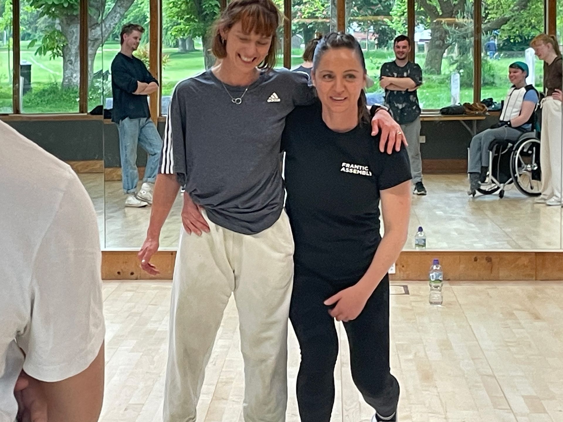 Two women are posing for a picture in a dance studio