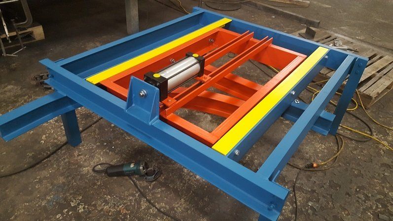 A blue and orange machine is sitting on the ground.