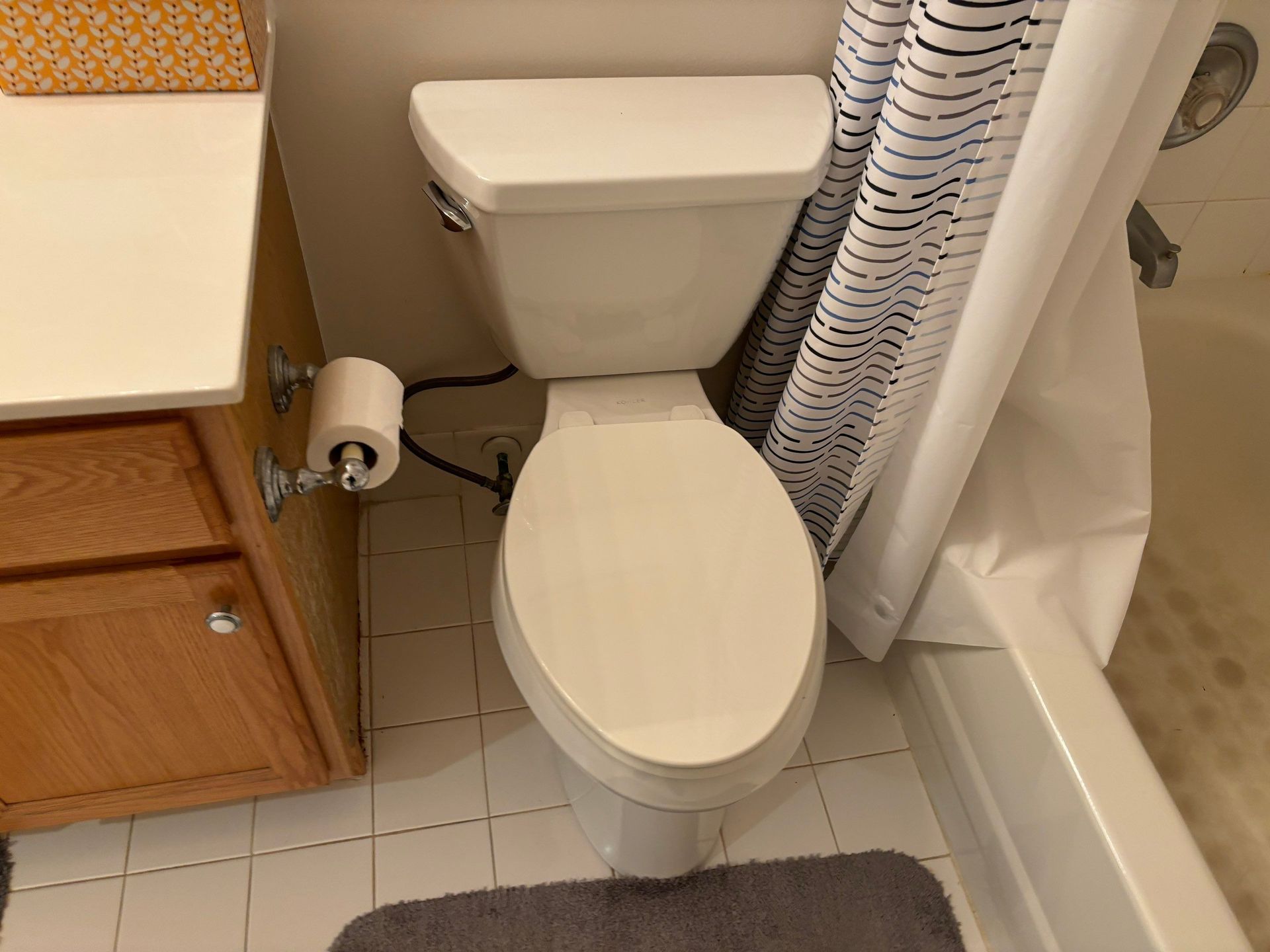 A bathroom with a toilet and a shower curtain