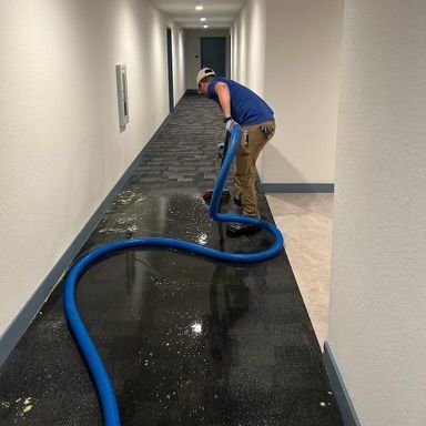 A woman in a blue shirt is working on a wall